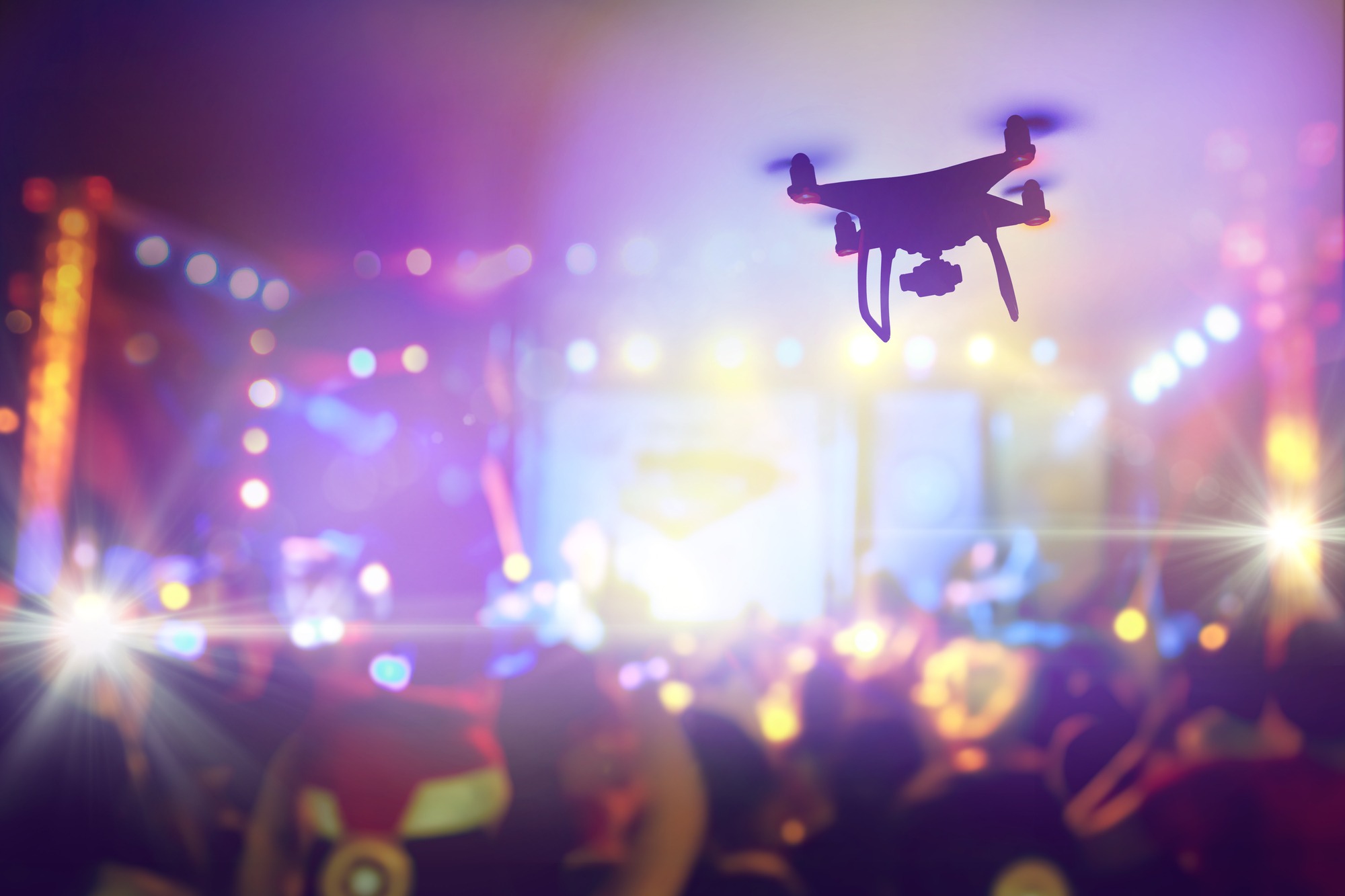 Drone silhouette flying above live concert